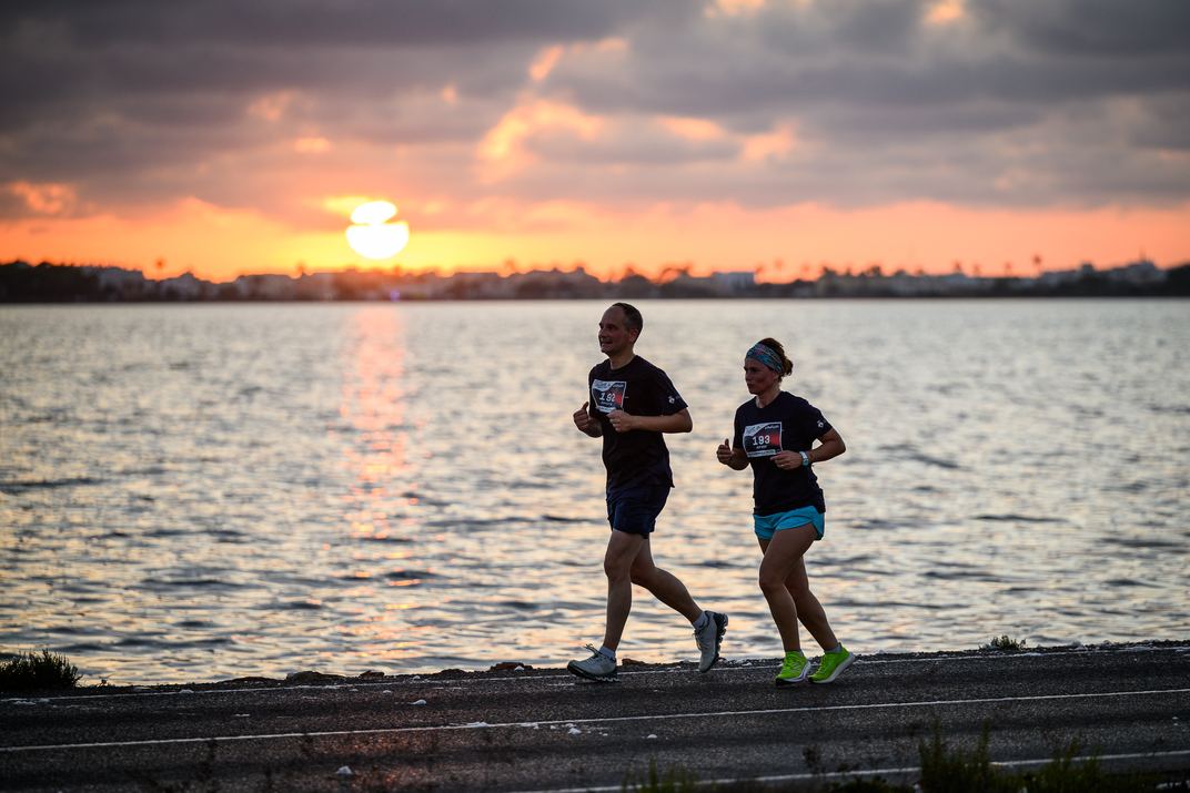 Dos corredores durante la 15K Formentera Sunset Run, con el sol en el horizonte